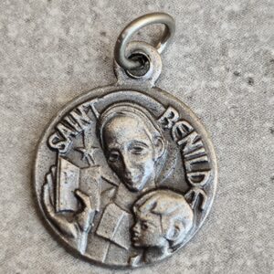 Médaille de saint benilde de couleur argent de forme ronde .