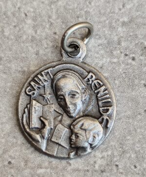 Médaille de saint benilde de couleur argent de forme ronde .